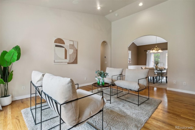 19770 Roaming Dr, Colorado Springs, CO 80908 - living area with arched walkways, wood finished floors, high vaulted ceiling, and a chandelier