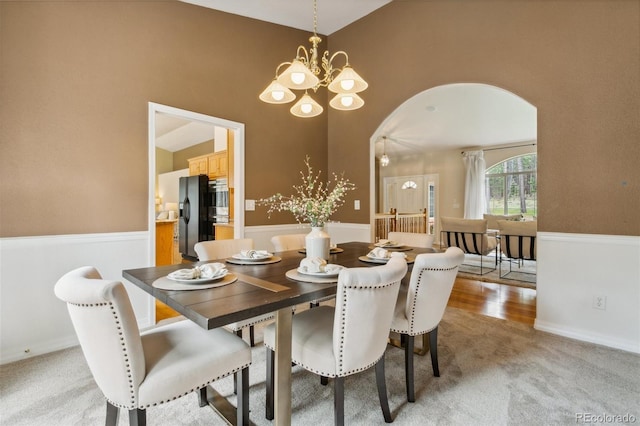 19770 Roaming Dr, Colorado Springs, CO 80908 - dining room featuring arched walkways, a chandelier, and light colored carpet