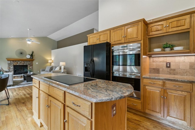 19770 Roaming Dr, Colorado Springs, CO 80908 - kitchen with black appliances, a center island, lofted ceiling, light wood finished floors, and a ceiling fan