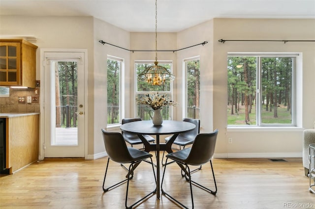 19770 Roaming Dr, Colorado Springs, CO 80908 - dining room featuring a chandelier, light wood-style floors, and plenty of natural light