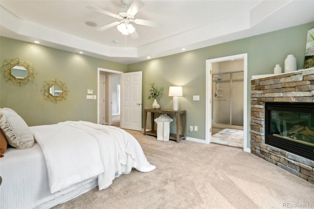 19770 Roaming Dr, Colorado Springs, CO 80908 - bedroom featuring a raised ceiling, light carpet, a stone fireplace, recessed lighting, and a ceiling fan