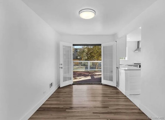 doorway to outside featuring wood finished floors, french doors, baseboards, and visible vents