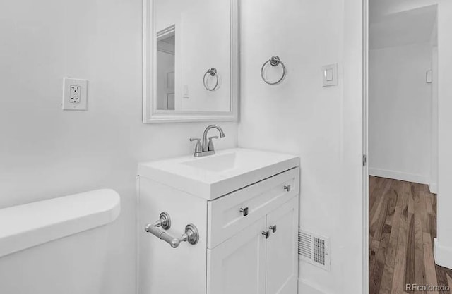 bathroom with visible vents, wood finished floors, and vanity