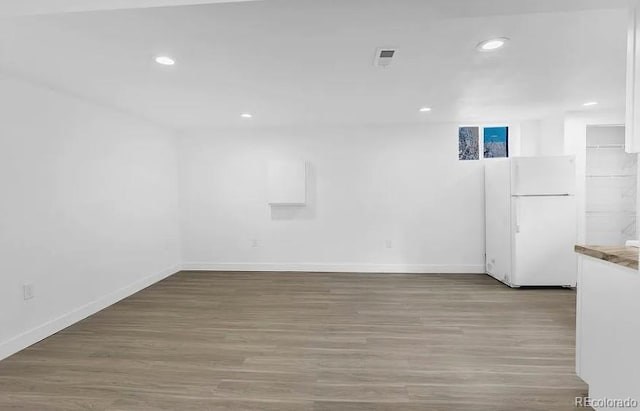 empty room featuring recessed lighting, baseboards, and wood finished floors