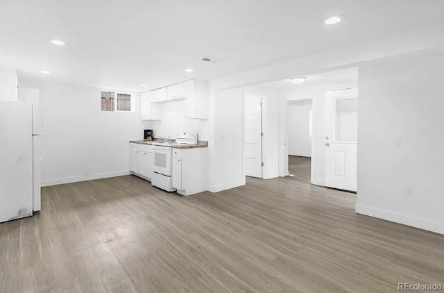 kitchen with wood finished floors, recessed lighting, white appliances, white cabinets, and baseboards