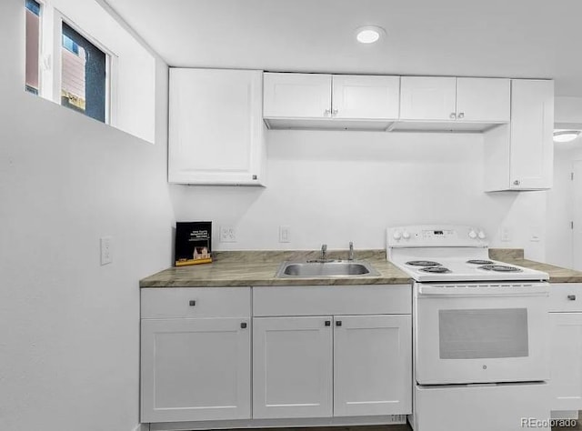 kitchen with white cabinetry, white electric range, and a sink