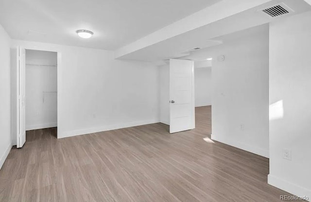 basement featuring visible vents, baseboards, and wood finished floors