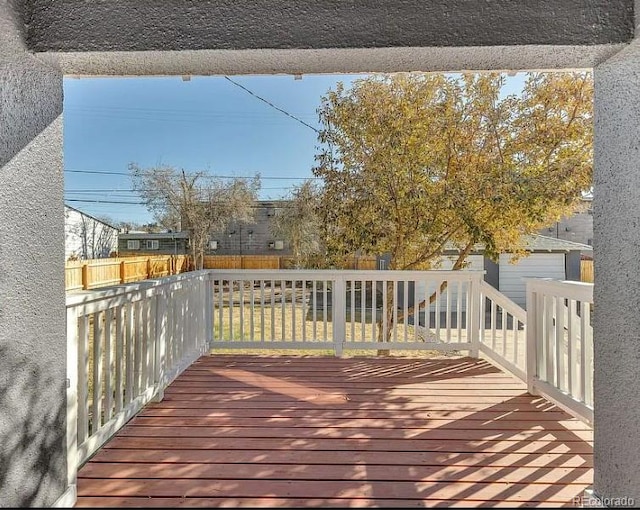 wooden terrace with a fenced backyard