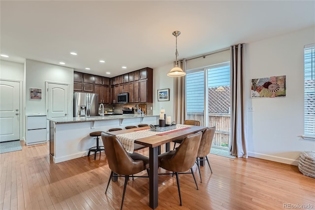 dining space featuring sink and light hardwood / wood-style flooring