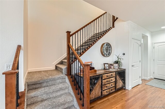 staircase with hardwood / wood-style floors