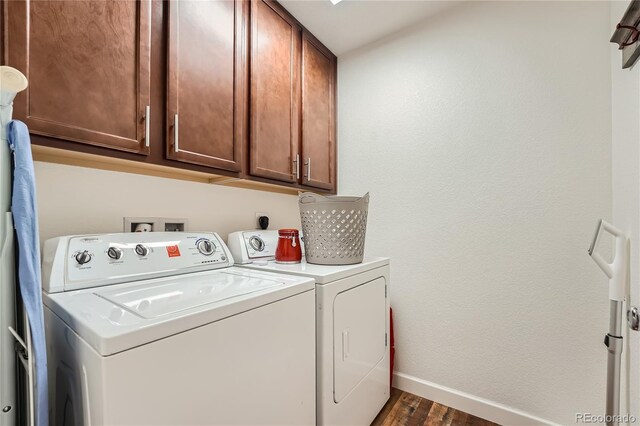 clothes washing area featuring cabinets, dark hardwood / wood-style flooring, and washing machine and dryer