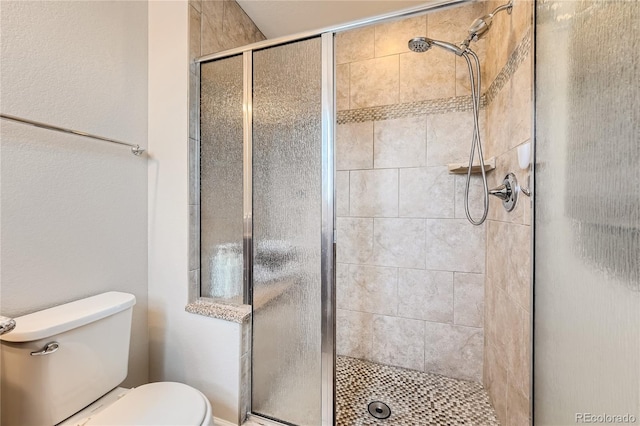 bathroom featuring toilet and an enclosed shower