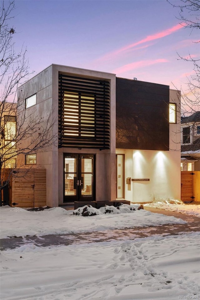 snow covered property featuring french doors