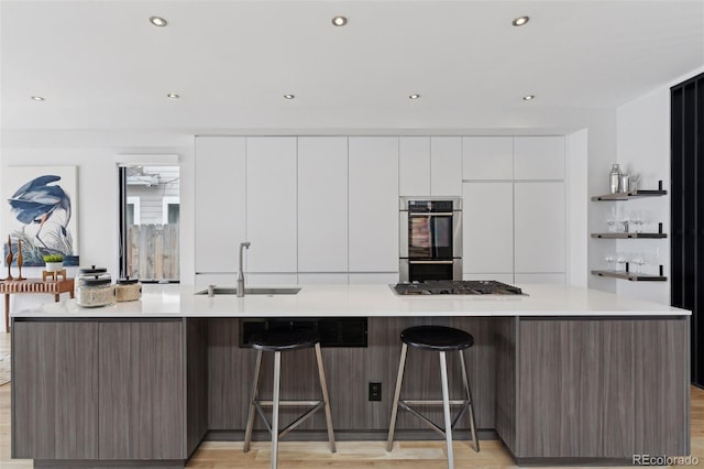 kitchen with sink, white cabinetry, a spacious island, and appliances with stainless steel finishes