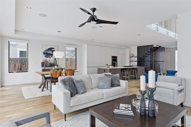 living room featuring light wood-type flooring and ceiling fan