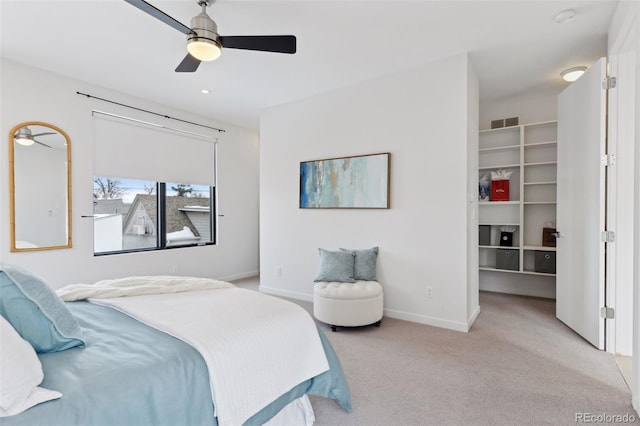 bedroom featuring ceiling fan, light colored carpet, a closet, and a walk in closet