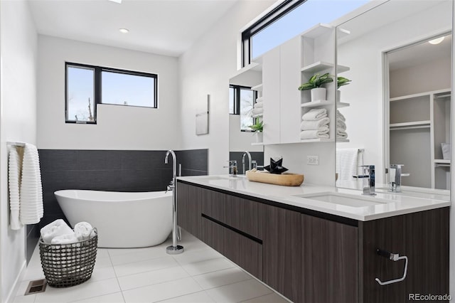 bathroom with vanity, a washtub, and tile patterned floors