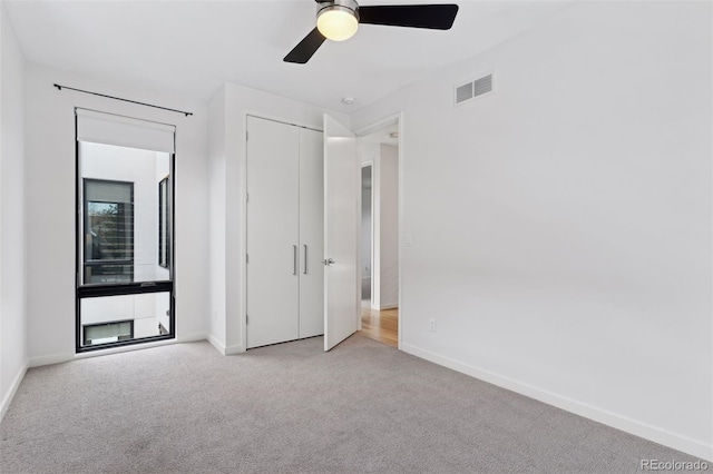 unfurnished bedroom with ceiling fan and light carpet