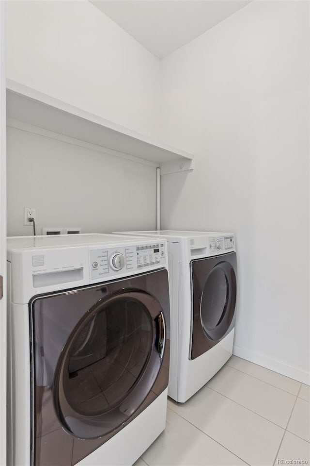 laundry room with light tile patterned floors and washing machine and clothes dryer