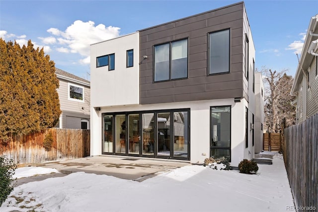 snow covered property featuring a patio area