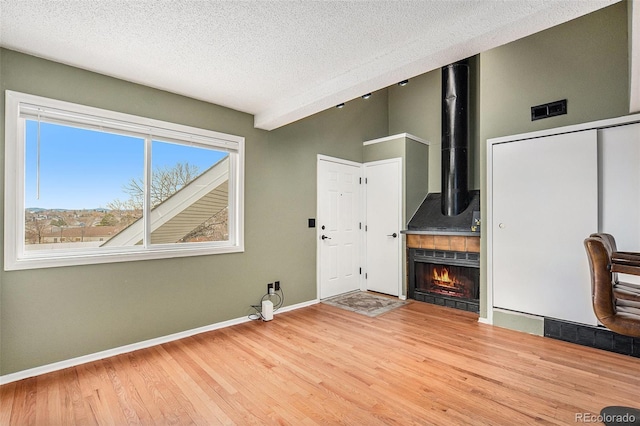 unfurnished living room featuring a textured ceiling and light hardwood / wood-style flooring