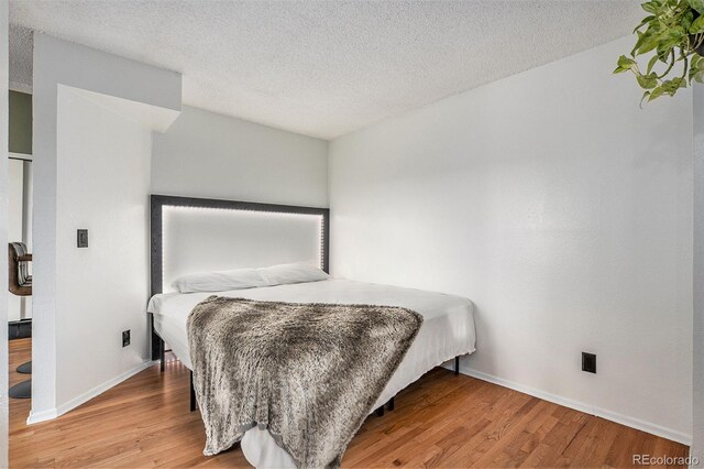 bedroom featuring wood-type flooring and a textured ceiling