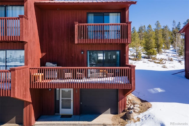 view of front of home with a balcony, a garage, and metal roof