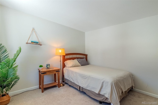 bedroom with baseboards and light colored carpet