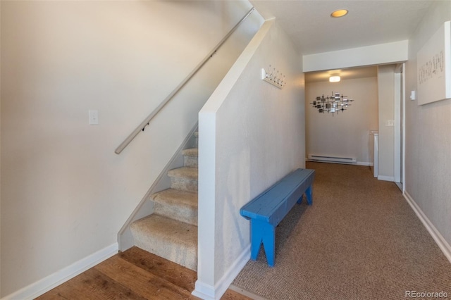 stairs with a baseboard radiator, wood finished floors, and baseboards