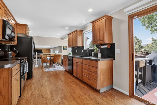9356 W Geddes Pl, Littleton, CO 80128 - kitchen with black appliances, crown molding, dark countertops, light wood finished floors, and plenty of natural light