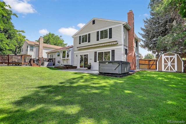 9356 W Geddes Pl, Littleton, CO 80128 - rear view of house featuring a hot tub, a chimney, a fenced backyard, a storage unit, and a wooden deck