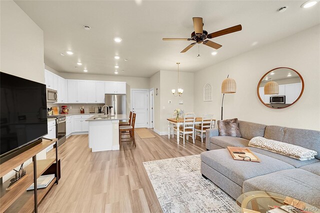18059 French Creek Ave, Parker, CO 80134 - living area featuring baseboards, recessed lighting, light wood-style flooring, and ceiling fan with notable chandelier