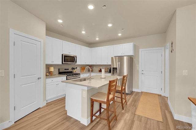 18059 French Creek Ave, Parker, CO 80134 - kitchen featuring a breakfast bar area, stainless steel appliances, light wood-type flooring, and a sink
