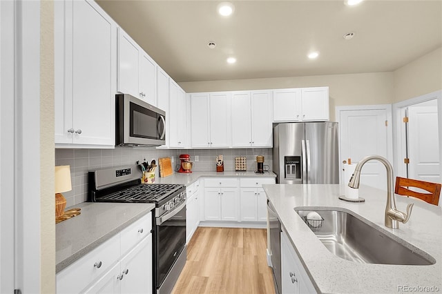 18059 French Creek Ave, Parker, CO 80134 - kitchen with light stone countertops, white cabinetry, stainless steel appliances, and a sink