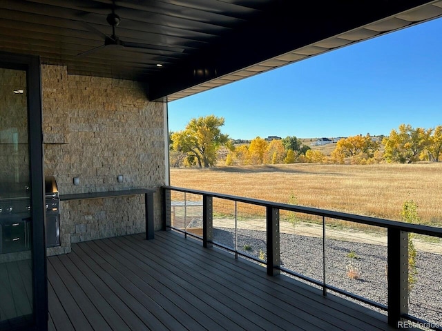 wooden terrace featuring a rural view and ceiling fan