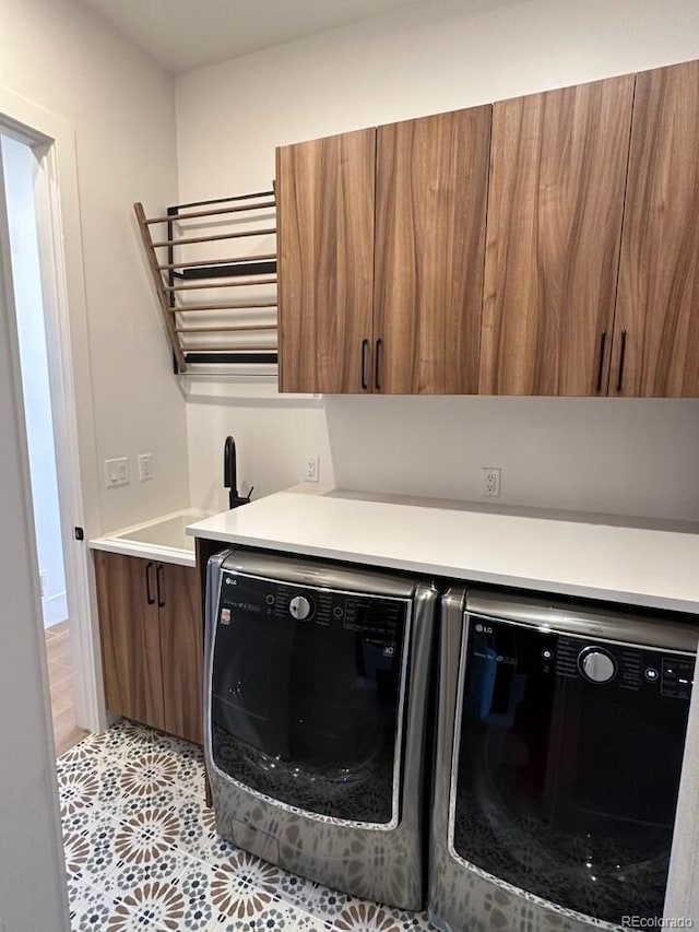 laundry area featuring sink, independent washer and dryer, light tile patterned flooring, and cabinets