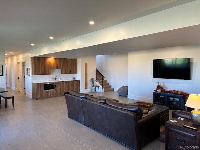 living room featuring sink and light tile patterned floors