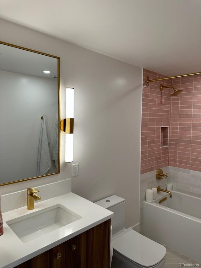 full bathroom featuring vanity, tiled shower / bath combo, and toilet