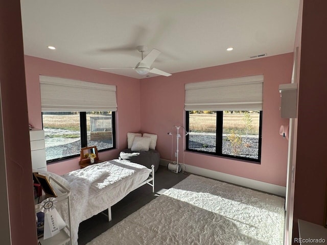 carpeted bedroom featuring ceiling fan and multiple windows