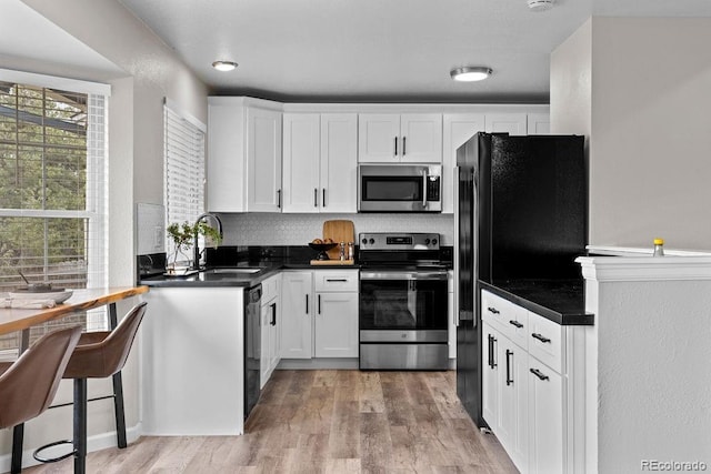 20908 E Dorado Cir, Centennial, CO 80015 - kitchen with black appliances, dark countertops, light wood-style flooring, and a sink