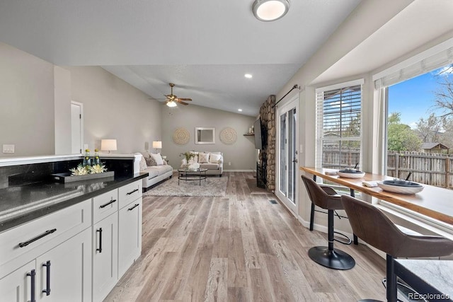 20908 E Dorado Cir, Centennial, CO 80015 - kitchen with vaulted ceiling, light wood finished floors, dark countertops, a ceiling fan, and white cabinets