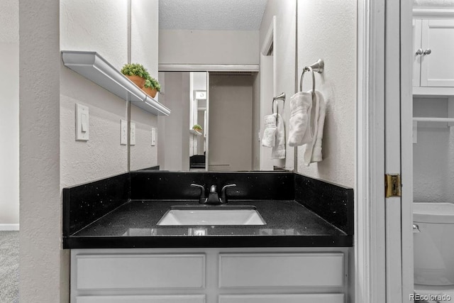 20908 E Dorado Cir, Centennial, CO 80015 - bathroom with toilet, vanity, a textured wall, and a textured ceiling