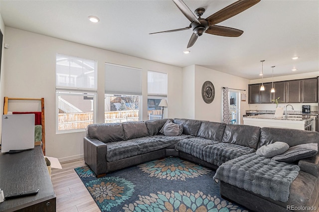 living room with ceiling fan and light wood-type flooring