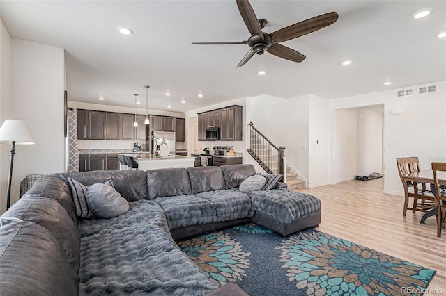 living room featuring ceiling fan and light wood-type flooring