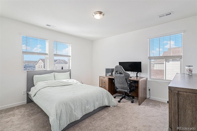 bedroom with multiple windows and light carpet