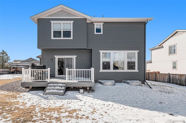 snow covered house featuring a deck