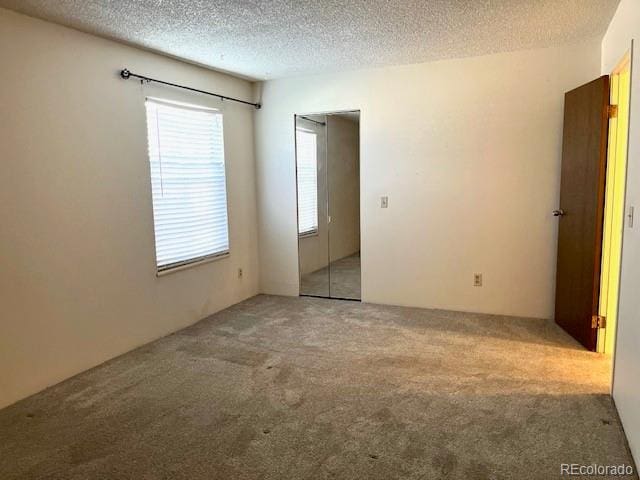 carpeted spare room featuring a textured ceiling