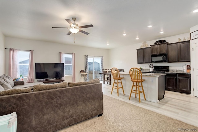 living room with ceiling fan, light wood finished floors, and recessed lighting