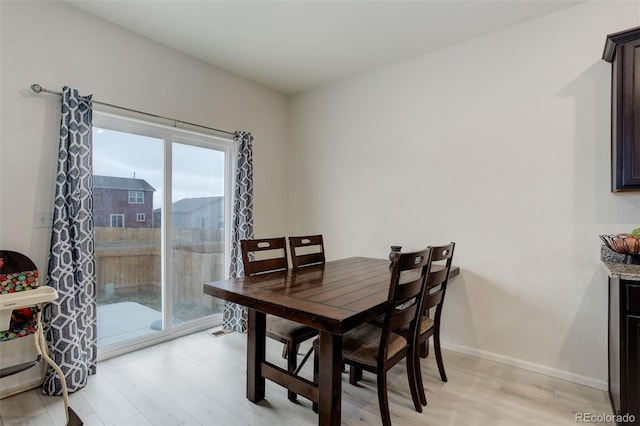 dining area with light wood-style flooring and baseboards