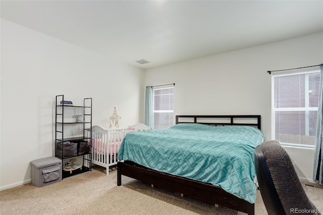 carpeted bedroom with multiple windows, visible vents, and baseboards